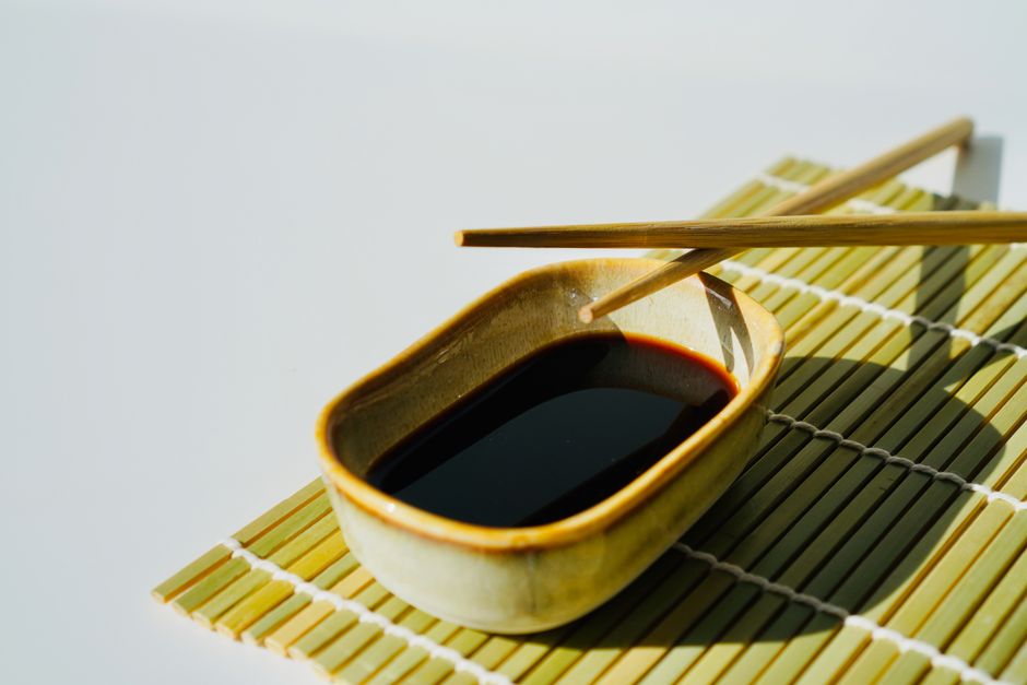 pexels-20843711-chinese-food-pairing-soy-douchi-oyster-sauce-wine-body-acidity 小碟酱油与筷子旁的中餐调味瓶,用于说明中餐配酒咸鲜度工具卡